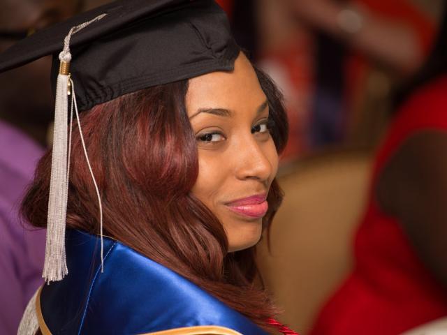 Smiling Blavin Scholar at graduation, wearing graduation cap.